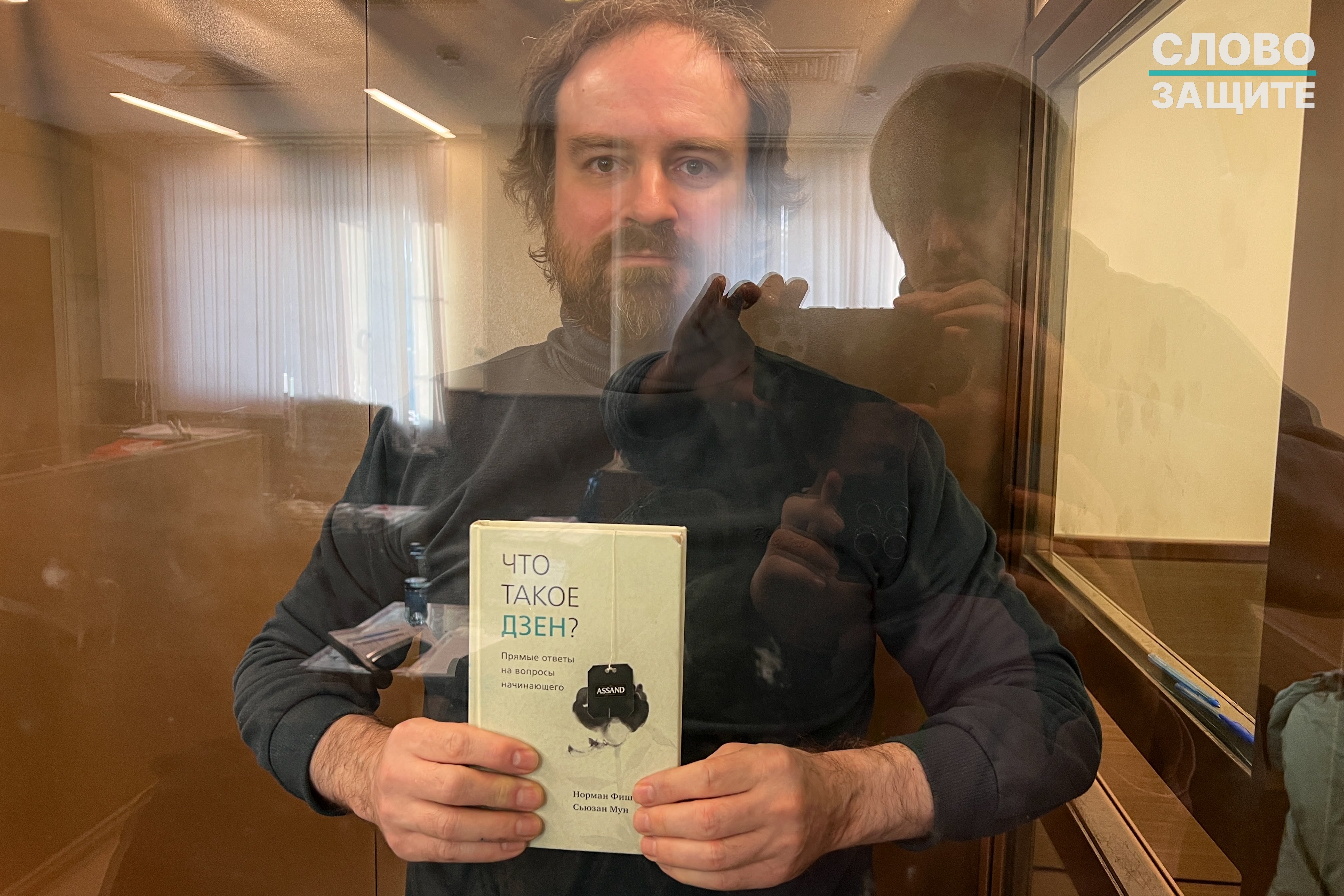 Илья Васильев с книгой «Что такое дзен?» в зале суда.